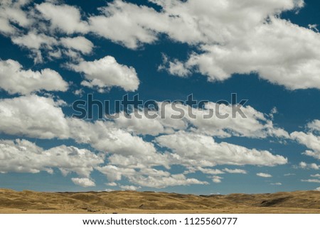 Beautiful countryside with mountains in the background, a blue sky and beautiful clouds in South America
