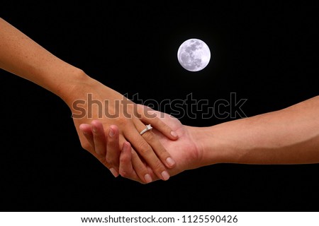 Engagement. A couple holds hand with the full moon sky background. Romantic Engagement with wedding right and full moon. 