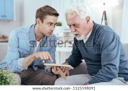 Unfamiliar person. Concerned senior man asking questions and man showing photo Royalty-Free Stock Photo #1125598091