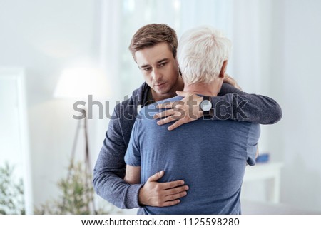 Sincere support. Sad man hugging senior man and looking down Royalty-Free Stock Photo #1125598280