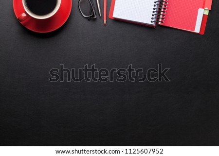 Office desk with coffee, notepad and supplies. Top view with space for your text