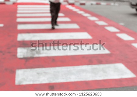 Blurred of People walking on a red crosswalk