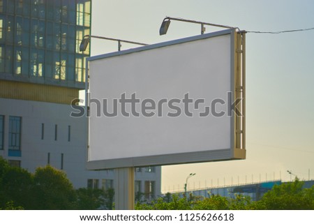 billboard white blank at sunset in the city. preparation for fitting advertising.
