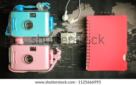 
Mp3 player with earphone note and cameras on world map background 