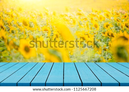 Wood table on background of beautiful yellow flower - can be used for display or montague your products.Mock up for display of product.