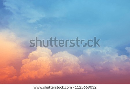 Yellow and red pink color light in fluffy clouds with dim blue sky
