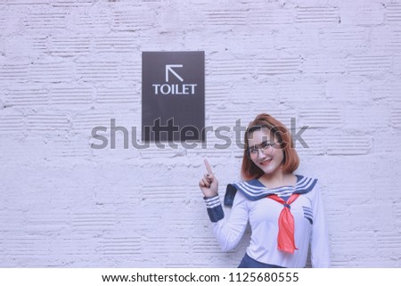 Young Asia Woman Point to the sign toilet