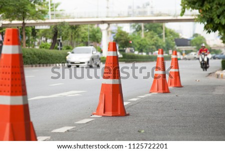 orange traffic cones standing in a row on the street.To prevent road accidents.
