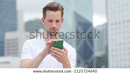 Caucasian young man use of mobile phone for text message