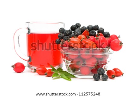 cup of tea with rose hips and different ripe berries on a white background close-up