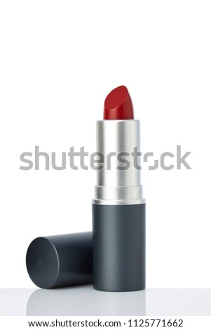 single tube of red lipstick on white