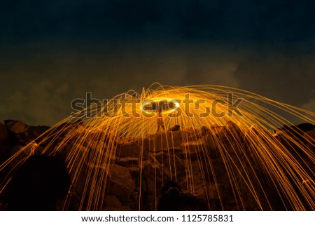 burning steel wool on the mountain rock above lagoon 