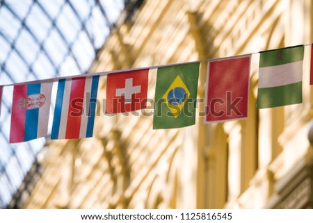 Decorative flags of the States on the blurred background of the building with a glass roof
