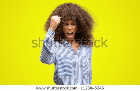 African american woman wearing a stripes shirt annoyed and frustrated shouting with anger, crazy and yelling with raised hand, anger concept