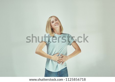 Happy freckled woman standing and smiling isolated on gray studio background. Beautiful female half-length portrait. Young emotional woman. The human emotions, facial expression concept. Front view.