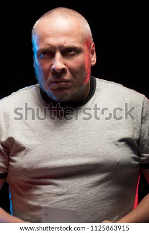 adult man in gray T-shirt posing on black background