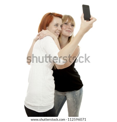 young beautiful red and blond haired girls doing self portrait with cell phone in front of white background