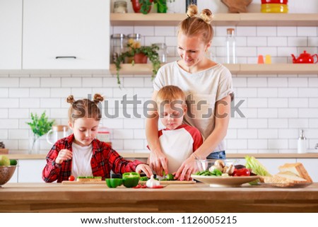 Picture of young mother with daughter and son cooking at table