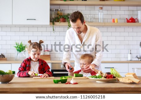 Photo of father with daughter and son cooking at table