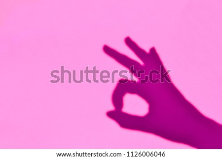 Shadow of symbolic OK sign created with human hands