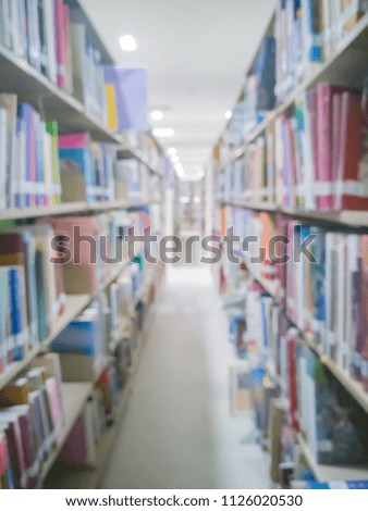 Blurred image of books, textbooks and magazines on bookshelves in public library or college for education concept
