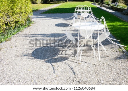 White chairs and tables outside in the garden