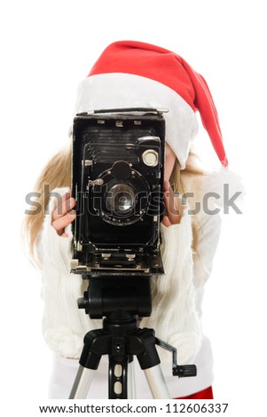 Girl in a Christmas costume with old camera on a white background.