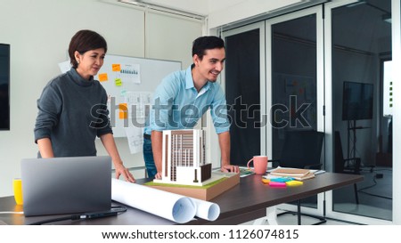 Architects team are working on a model building. Woman suggest requirement to designer. concept of construction, architecture, development and creative.