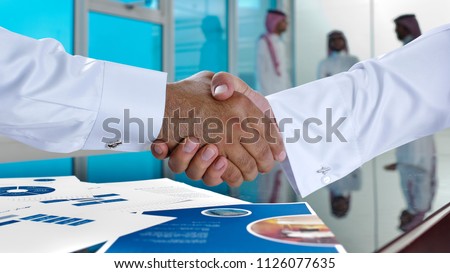 Saudi Arab businessmen shaking hands, and making agreement or a deal in a meeting room Royalty-Free Stock Photo #1126077635