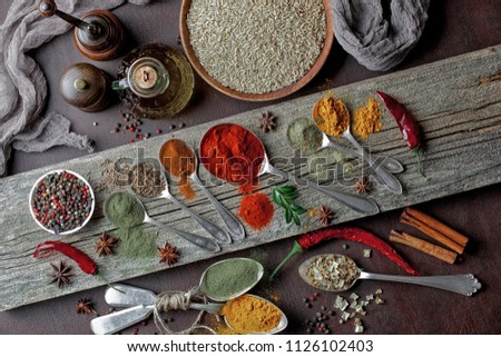 Spices for cooking with kitchen accessories on an old background