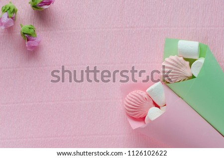 Pink and green cones with marshmallows and malvas on the pink background.Top view.Minimalism. Copy space