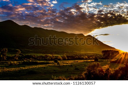 Colorful sunset over the highway near a mountain and a forest
