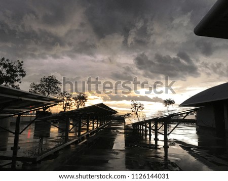 Solar energy panels on the terrace in the evening, scenery of the sunset and rain clouds. 