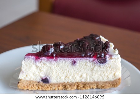 Blueberry Cheesecake Pie on white plate with wooden table background with copy space.