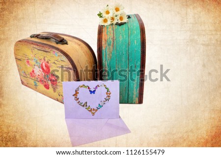Vintage colored tough suitcases. Post envelope and flowers. Butterfly  fluttering. Memory romantic love memories of travel. Old paper texture