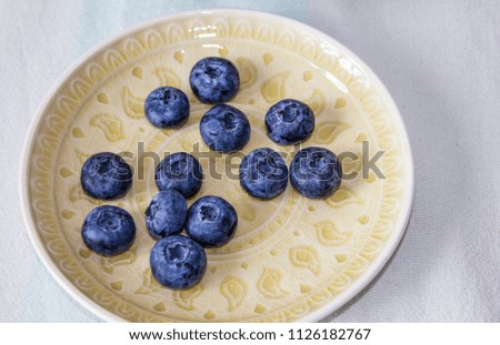 ripe juicy blueberries on a ceramic plate