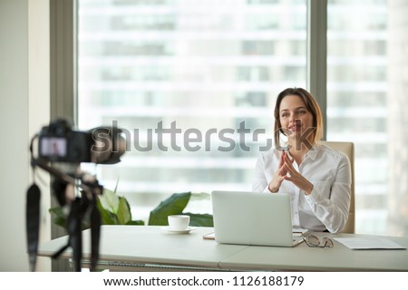 Confident focused businesswoman vlogger talking to camera filming live business vlog concept, friendly female coach advertising online training speaking about success recording video blog in office
