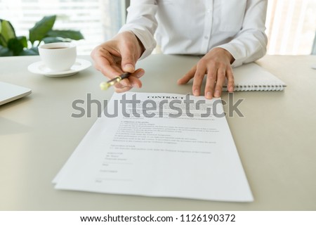 Woman gives pen offers to sign new job employment contract, partner promising good deal convincing to agree on terms of loan insurance put signature on legal business document concept, close up view Royalty-Free Stock Photo #1126190372