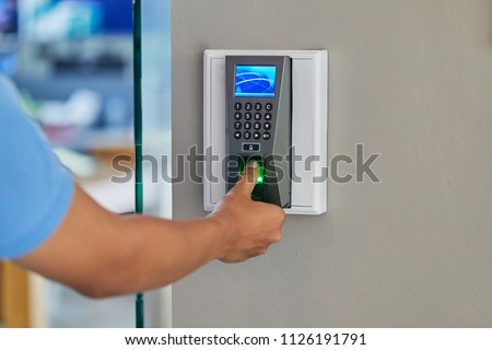 People or man push finger down on the electronic control machine to access the door. Selective focus