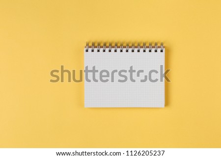 notebook on a yellow background top view, blank sheet for writing purposes, business concept flat lay