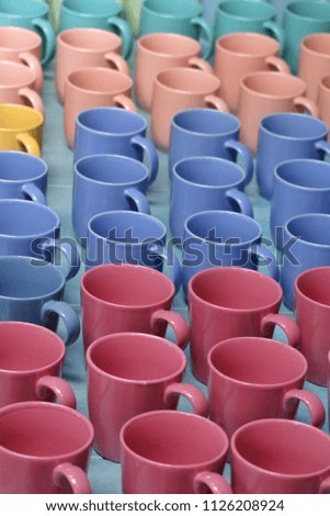 Many multicolored cups display in front of the pottery shop at the market