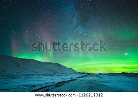 Aurora borealis showing many colors as it is dancing in the sky above the mountains in Tinn, Norway