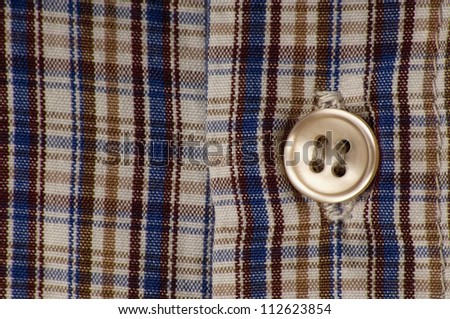 Close-up of colorful squared shirt with button