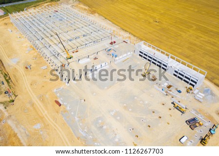 Aerial view of factory construction site. Building up large manufacturing plant in industrial zone on suburb of Dobrany city, Czech Republic, Europe.