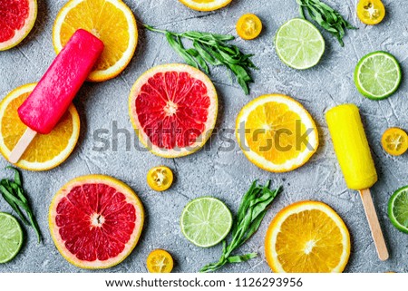 citrus popsicles with fruit slices on stone background top view 