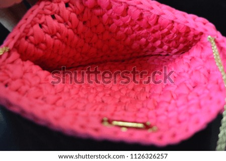 Women's small bag with gold chains and a lock on a smooth reflecting background