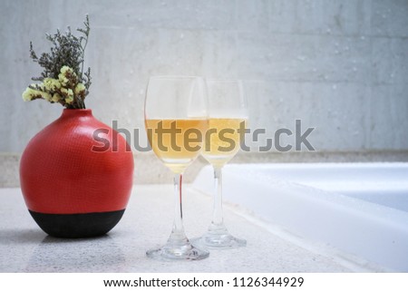 Two glasses of fruit wine put near bathtub in the spa as relaxation on cept