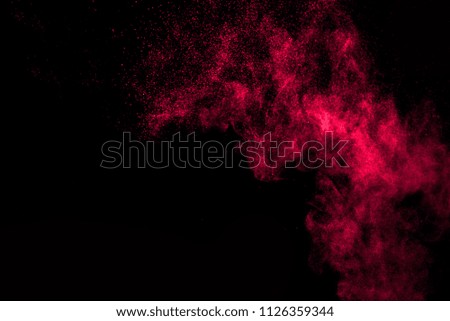 The explosion of red dust on a black background.