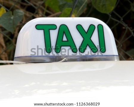 Close up of an taxi sign and its reflection