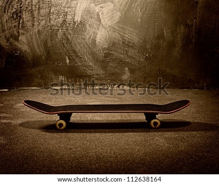 Skateboard against grunge wall